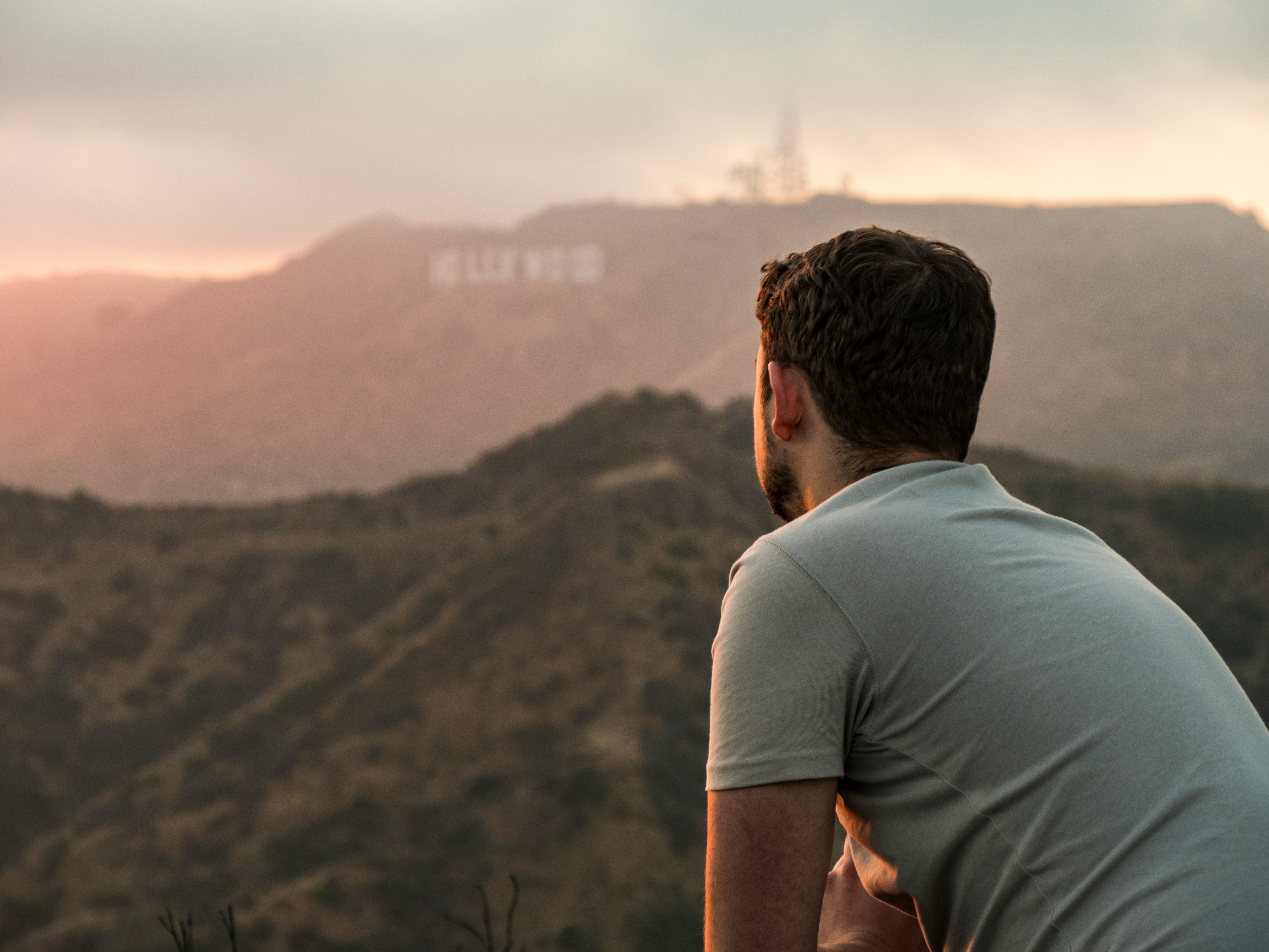 man standing in front of Hollywood signage